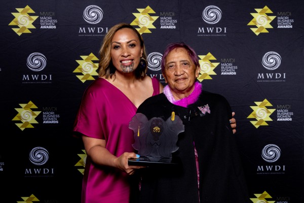 Two women pose with award